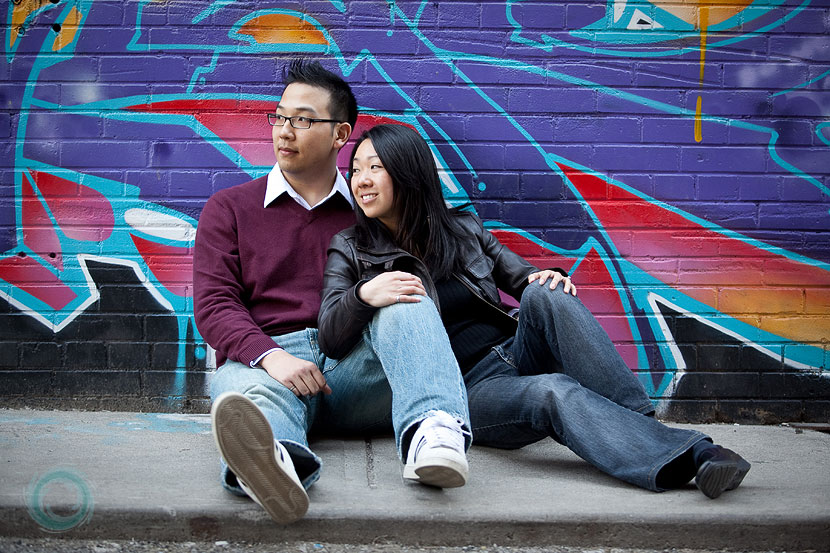 cool-engagement-photo-sitting-by-a-graffiti-wall cool-engagement-photo-sitting-by-a-graffiti-wall