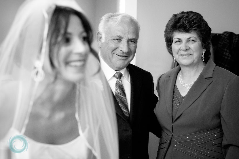 mother-and-father-watching-the-bride-putting-on-finishing-touches mother-and-father-watching-the-bride-putting-on-finishing-touches