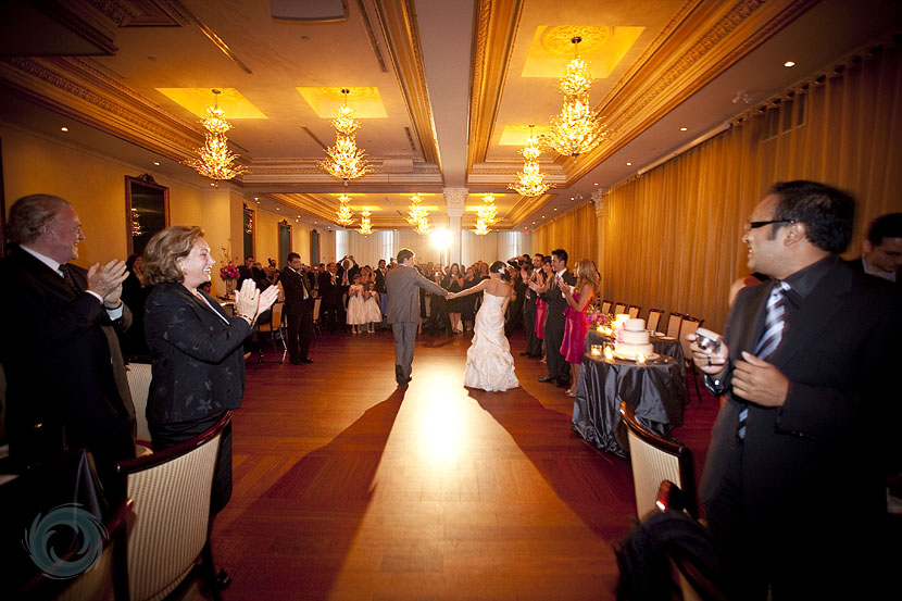 35-the bride and groom entering their reception at the rosewater room